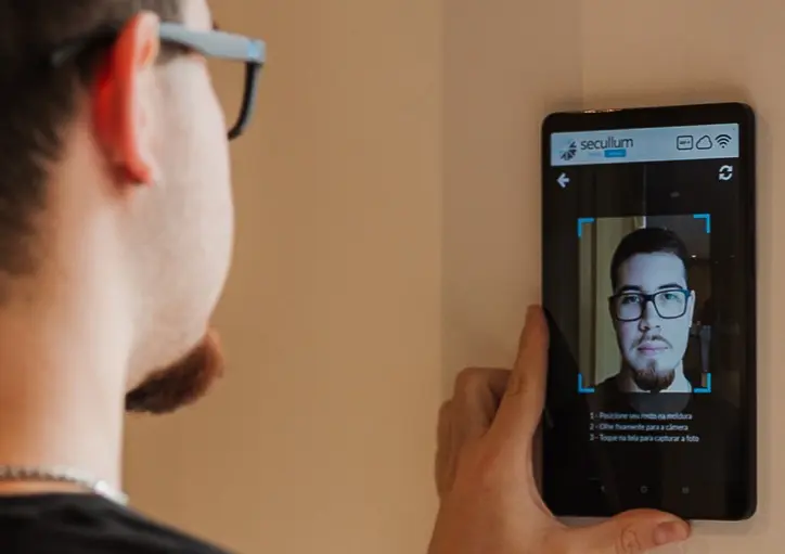 Homem olhando para o tablet e realizando o reconhecimento facial